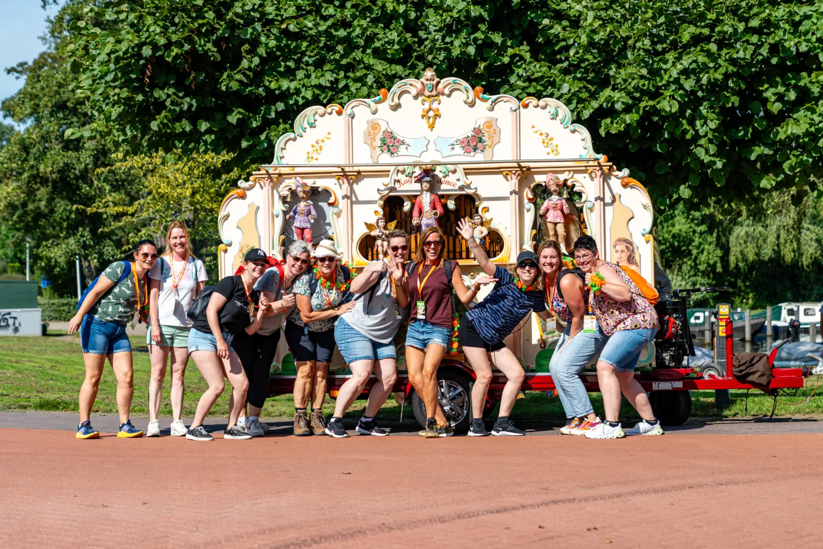 Een groep wandelaars poseert lachend voor een draaiorgel langs de route